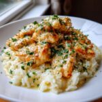 Golden seared chicken scampi pieces served over creamy garlic parmesan rice, garnished with parsley.
