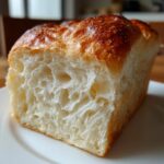 Close-up of a slice of japanese milk bread showing its incredibly soft, feathery, and white interior crumb.
