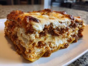 Close-up of a thick, layered slice of Lasagna with Cottage Cheese, featuring rich meat sauce and a browned, bubbly cheese top.