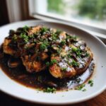 Three breaded cutlets of Chicken Marsala smothered in a dark mushroom sauce and topped with fresh parsley.