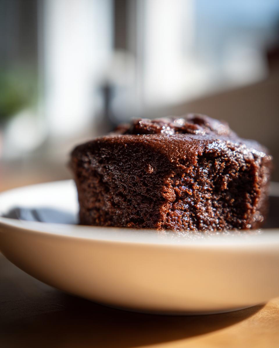 Close-up of a rich, dark portion of homemade chocolate pudding served in a light-colored bowl.