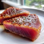Two perfectly seared tuna steaks, rare in the center, coated in a flavorful MARINADE FOR TUNA STEAK seasoning.