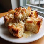 Close-up of pull-apart cheese bread pieces with incredibly stretchy, melted cheese strings, perfect for comfort food.