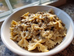 Close-up of creamy beef pasta made with farfalle (bowtie) noodles, seasoned with pepper.