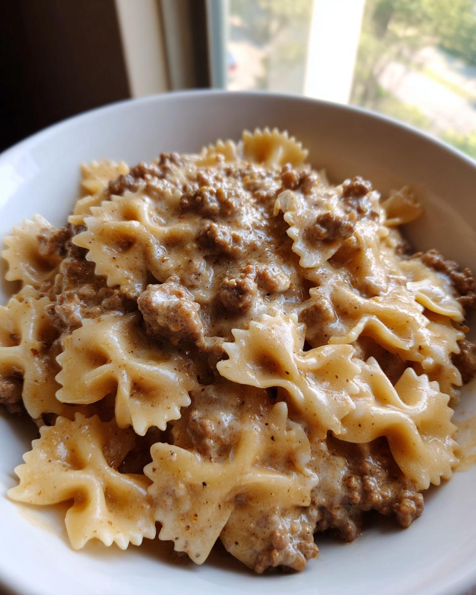 Close-up of creamy beef pasta made with farfalle (bowtie) noodles coated in a rich, savory sauce.