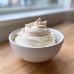 A close-up of creamy, whipped 3-ingredient fruit dip mounded high in a small white bowl.