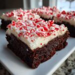 A rich, fudgy square of peppermint brownies topped with thick white frosting and crushed candy canes.