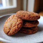 A stack of four rich, brown sugar cookies coated in sparkling sugar, ready to enjoy.