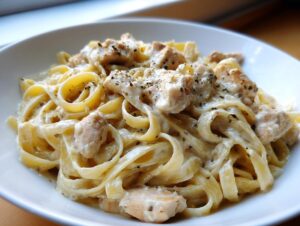 Close-up of creamy chicken fettuccine alfredo pasta tossed in rich white sauce and topped with herbs.