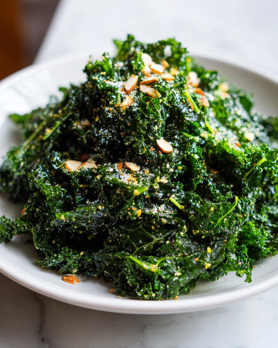 A close-up of a vibrant, dark green kale salad topped with slivered almonds and grated cheese.