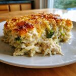 A generous slice of creamy chicken and broccoli rice casserole with a golden, cheesy crust.