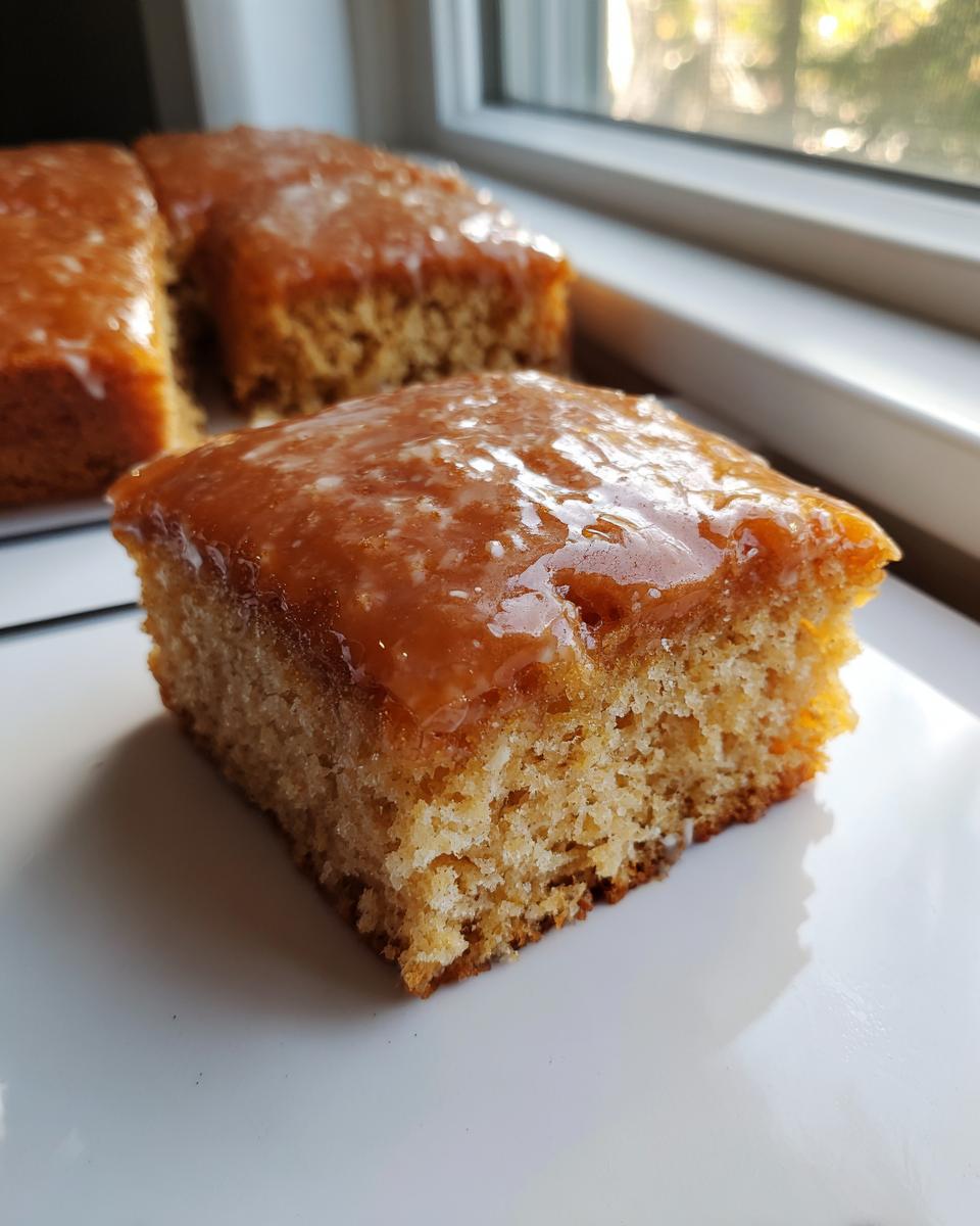 Close-up of a soft maple donut bars square with a thick, shiny maple glaze topping.