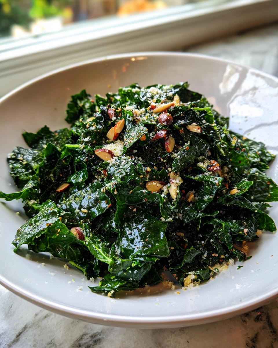 Close-up of a vibrant kale salad tossed with sliced almonds and grated cheese.