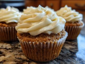 Close-up of a moist banana cupcakes topped with a swirl of creamy white frosting.