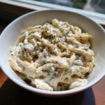 Close-up of creamy cottage cheese pasta coated in a rich sauce and topped with black pepper.
