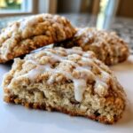 Close-up of a soft, crumbly coffee cake cookie drizzled with white vanilla glaze, showing the interior texture.