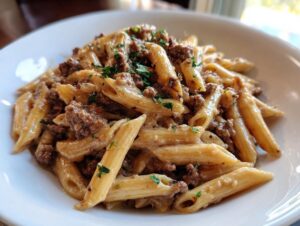 Close-up of a serving of one-pot creamy beef and garlic butter pasta with penne noodles and ground beef.