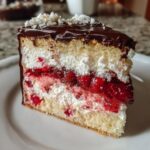 Close-up of a decadent slice of strawberry chocolate shell cake showing layers of sponge, cream, and strawberry filling.