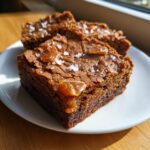 Close-up of fudgy homemade butterscotch brownies topped with caramel pieces and flaky sea salt.