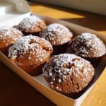 Six rich brown mini cakes dusted with powdered sugar, ready for a picnic, showcasing Mini cake picnic flights.